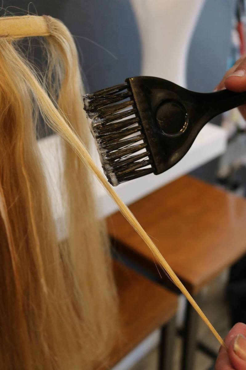 Color being brushed onto long blonde hair